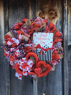 a valentine's day wreath hanging on a wooden door