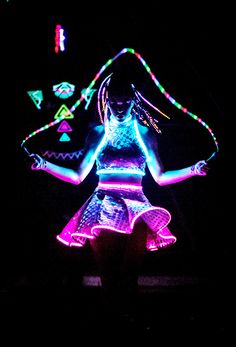 a woman is dancing with neon lights on her body