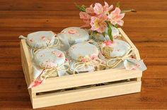 a wooden box filled with lots of cookies and pink flowers on top of a table