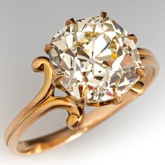 an old mine cut diamond in a yellow gold ring, set with filigrees