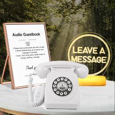 an old fashioned phone sitting on top of a table next to a sign that says leave a message