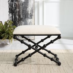 a black and white bench sitting on top of a rug next to a potted plant