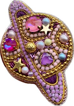 a purple brooch with lots of beads and stars on it's back side