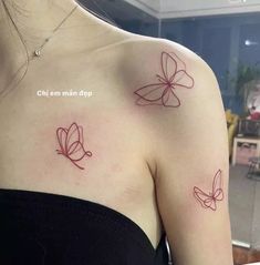 two small butterflies on the back of a woman's left shoulder, both with red ink