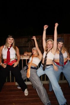 four young women are posing for the camera with their arms in the air while wearing ties