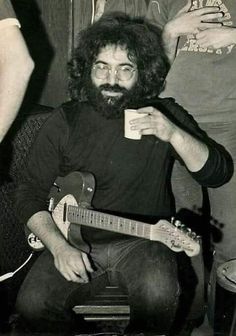 black and white photograph of a man holding a guitar