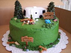 a green cake decorated with camping related items