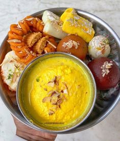 a metal bowl filled with different types of food