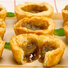 several small pastries are sitting on a tray with green leafy garnishes