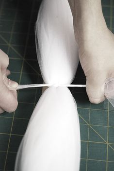 a person is cutting something with scissors on a table next to a pair of feet