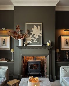 a living room filled with furniture and a fire place in front of a painting on the wall