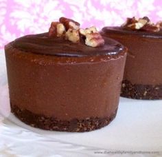 two chocolate cheesecakes on a white plate with pink wall in the back ground