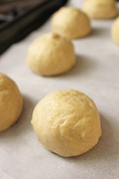 doughnuts lined up on a baking sheet ready for the oven to be baked