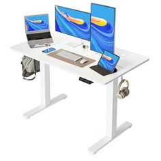 two computer monitors sitting on top of a white desk next to a laptop and monitor