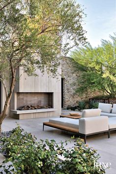 an outdoor living area with couches and a fire place in the middle of it