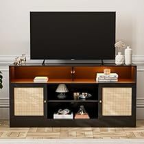 a flat screen tv sitting on top of a wooden entertainment center next to a potted plant