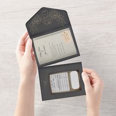 two hands holding an open passport case with a card in it and another person's hand on the other side