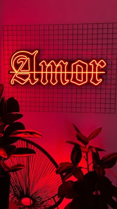 a neon sign that says amoe on the side of a wall next to potted plants