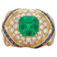 Vintage 1980s Mauboussin Emerald Ring with Diamonds and Sapphires For Sale at 1stDibs Art Deco Yellow Gold Emerald Ring With Brilliant Cut, Luxury Gold Emerald Ring Collectible, Luxury Yellow Gold Emerald Ring For Formal Occasions, Luxury Gold Emerald Collectible Ring, Luxury Diamond Emerald Ring Collectible, Luxury Yellow Gold Emerald Ring With Diamond, Elegant Yellow Gold Emerald Ring, Collectible, Luxury Yellow Gold Emerald Baguette Cut Ring, Luxury Yellow Gold Emerald Ring With Baguette Cut