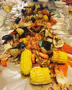 a table topped with lots of seafood and corn on the cob