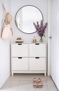 a white dresser sitting next to a mirror