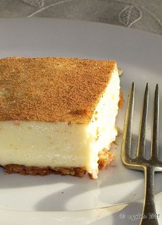 a piece of cheesecake sitting on top of a white plate next to a fork