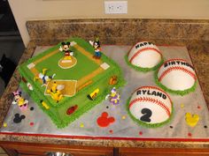 two mickey mouse cakes with baseballs and other decorations