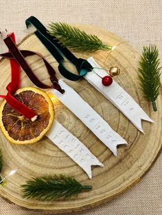 three orange slices on a wooden plate with ribbon and ornaments around them, sitting on a table