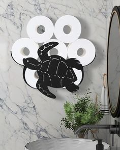 a bathroom with a sink, toilet paper and a turtle on the wall