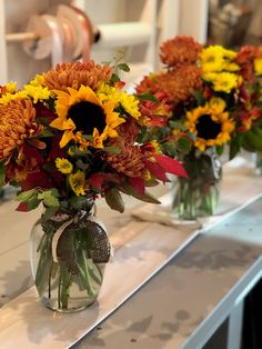 three vases filled with yellow and red flowers