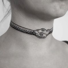 a woman's neck with a snake tattoo on it