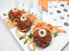 two spaghetti balls with googly eyes on them are sitting on a plate next to silverware