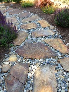 a stone path in the middle of a garden