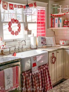 an instagram photo of a kitchen decorated for christmas with red and white decorations on the window sill