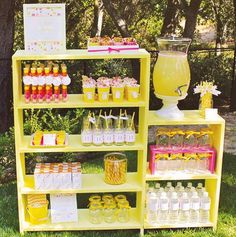 a yellow shelf filled with lots of different types of drinks and desserts on top of it