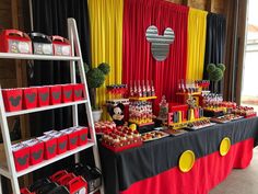 a mickey mouse themed birthday party with red, yellow and black desserts on display