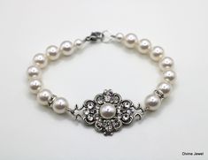 "This charming  bracelet has antique silver filigree decorated with premiums Austrian crystals and pearls.  Filigree measures just under 1 1/2\" by 7/8\" at its widest point and it's been decorated with different shapes and sizes of crystals and pearls.  White Austrian pearls measure 8 and 6 mm and are accented with rhinestone roundelles. Finished off with a lobster clasp and 1\" extender for additional length.    Bracelet is approximately 7 1/2\" long.  Length can be adjusted up to 8 1/2\" long Elegant Pearl Bracelet For Wedding With Intricate Design, Elegant Pearl Bracelet With Intricate Design For Wedding, Elegant Wedding Pearl Bracelet With Intricate Design, Vintage Pearl Bracelet For Wedding, Vintage Silver Pearl Bracelets, Vintage Silver Pearl Bracelet, Wedding Pearl Bracelet, Bridal Pearl Bracelet, Charming Bracelet