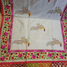 an embroidered cloth with birds and flowers on it