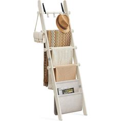 a white wooden ladder with two baskets and a hat on the top shelf next to it