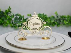 a white plate topped with two place settings and an ornate nameplate on top of it