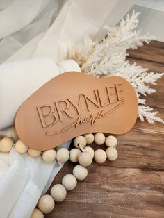 some white and brown beads on a wooden table with the name brynle made