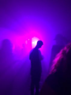 a man standing in front of a purple light