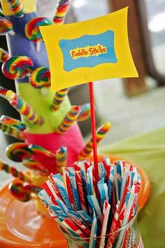 colorful candy sticks in a vase with a flag sticking out of it's top