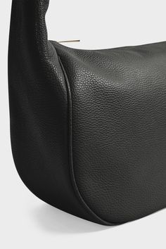 The Halo Crossbody in black celebrates a streamlined, minimal style with a full zip closure for everyday wear. In a satisfying, seamless flow from side to side, the piece is defined by its curved body into strap appeal. It’s an elevating feature that leans strongly into a feel of daily, private luxury for the wearer. With an effortless nature and ability to soften and sink at the body’s center, the piece finds its footing as a luxe, hobo-style, day bag. Ideal as a work bag and travel bag. Handcr Black Smooth Grain Hobo Bag For Business, Modern Crossbody Hobo Bag With Smooth Grain, Versatile Black Soft Leather Baguette Bag, Minimalist Black Shoulder Bag With Smooth Grain, Modern Black Hobo Bag With Smooth Grain, Black Smooth Grain Crossbody Shoulder Bag, Modern Baguette Bag With Zipper Closure For Business, Modern Baguette Bag With Zipper For Business, Practical Fashion