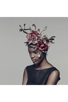 a woman with flowers on her head and spoons sticking out of the top of her head