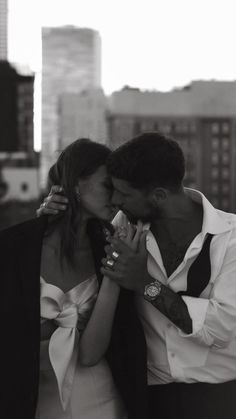 a man and woman kissing in front of a city skyline