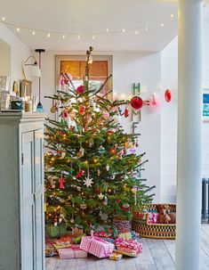 a decorated christmas tree in the corner of a room