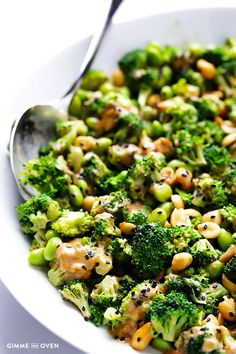 a white bowl filled with broccoli and chickpeas next to a spoon