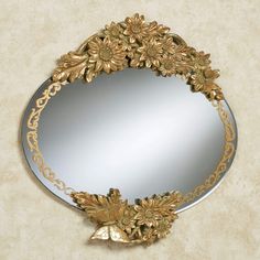 a round mirror with gold flowers on it