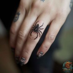 a woman's hand with a spider tattoo on it